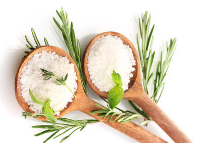 salt in spoons with fresh basil, thyme and rosemary isolated on white